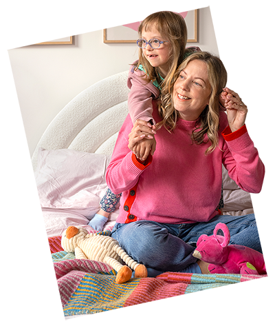 image of a mother and daughter sitting on a bed